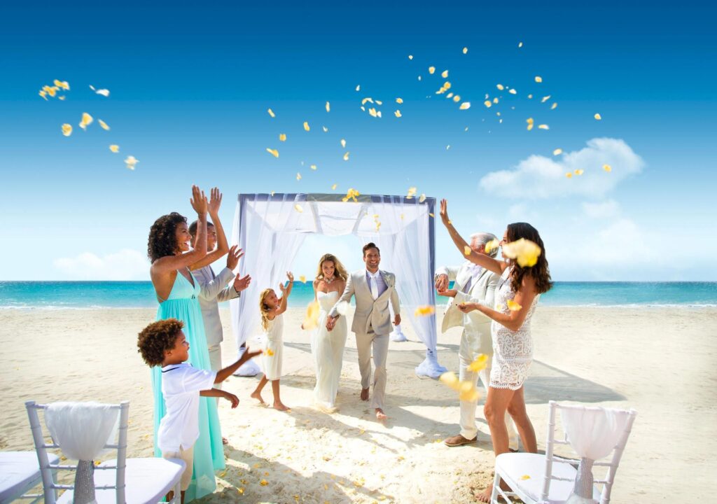 Beach wedding ceremony with guests celebrating joyfully.