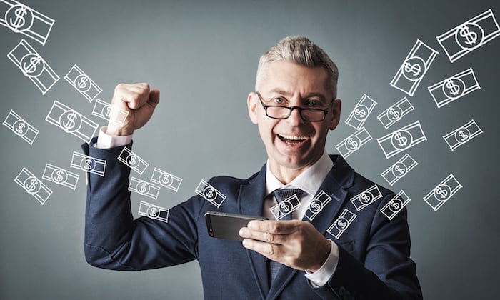 Man celebrating with smartphone and money graphics.