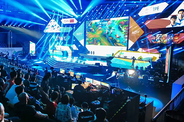 Esports tournament with vibrant stage and audience.